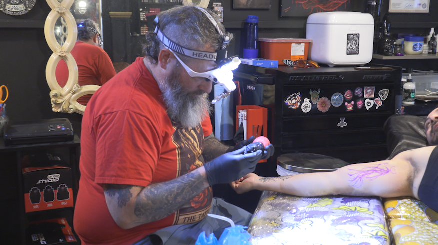 Scott Crandall adjusting his tattoo machine