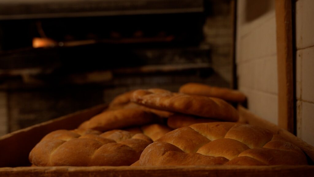 Fresh pile of bread loaves in a large wooden box