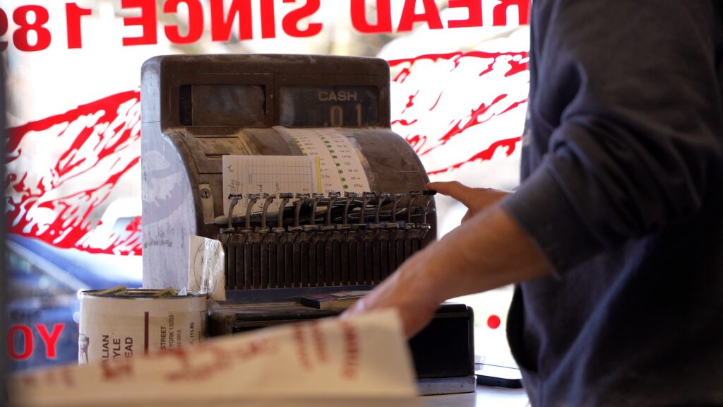 Close up of man cashing out at old cash register from the 1800's
