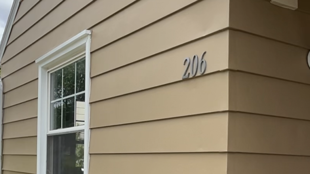 A house with tan siding and the numbers 206