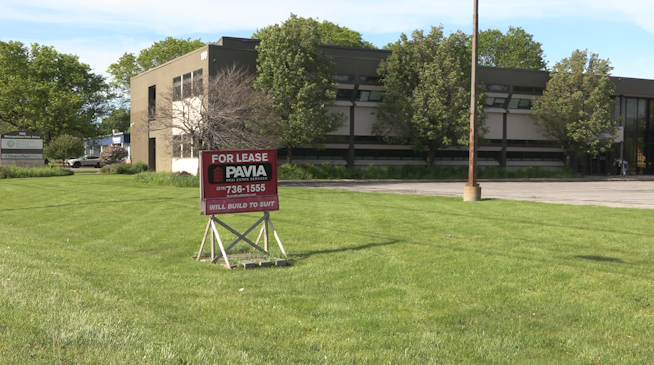 Former Berkshire Hathaway offices in Liverpool on Henry Clay Boulivard that have a red for lease sign in front from Pavia Real Estate. 