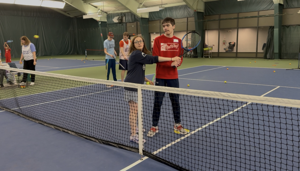 Eileen Horgan and a player going over how to perform a forehand. 