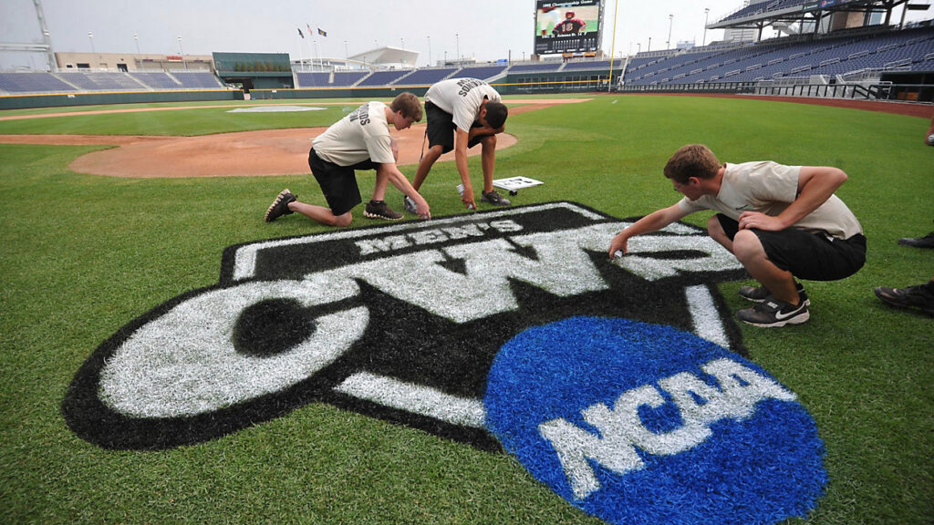 Members of the CWS grounds crews spray painting the CWS logo on the grass.