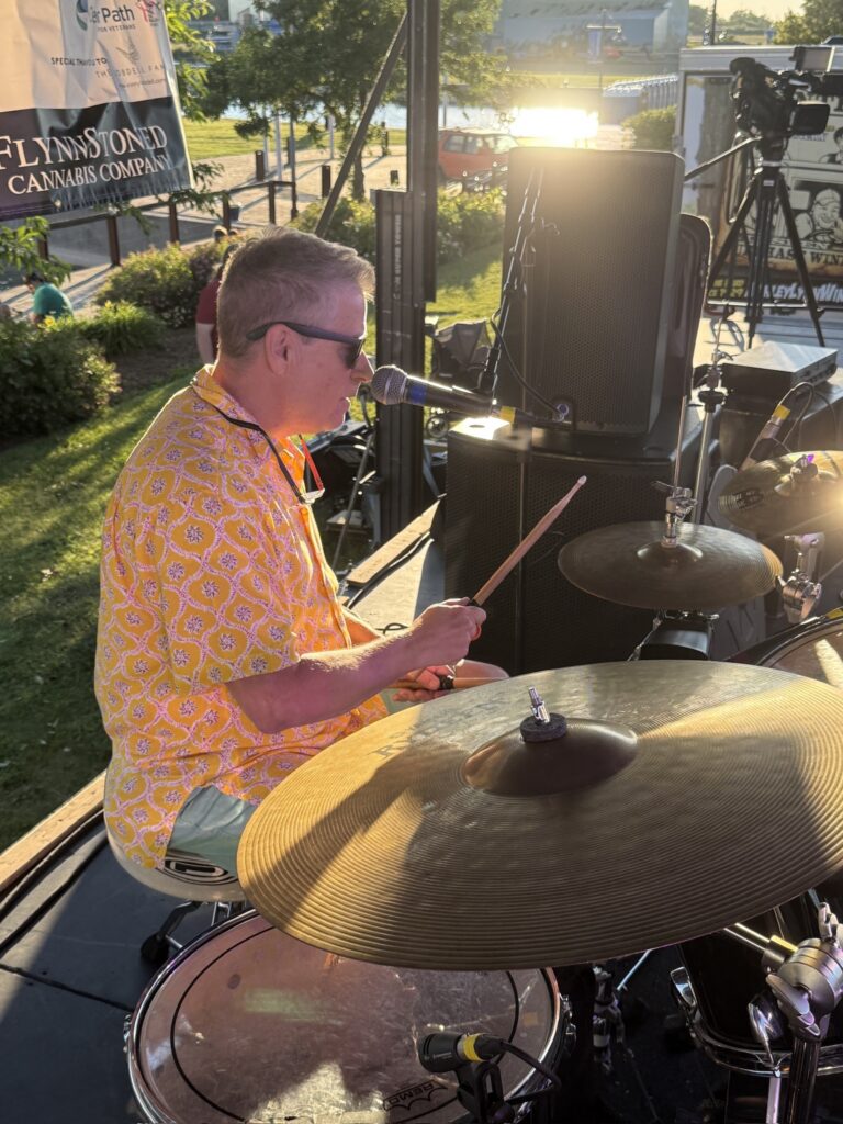 Man in yellow shirt playing the drums