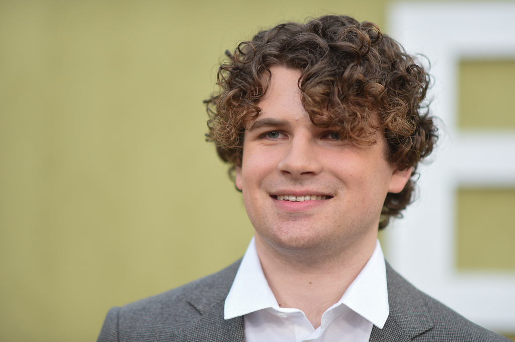 Kane Parsons is pictured in front of the yellow wall of the Backrooms title at a red carpet premiere.