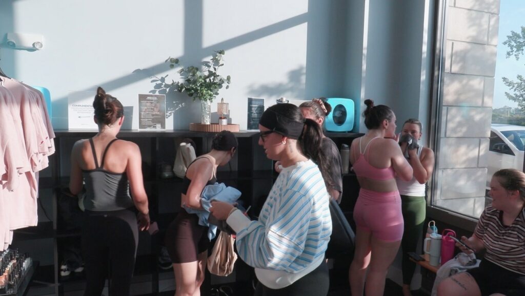 girls with workout sets on inside of a lobby, grabbing their items out of their cubby