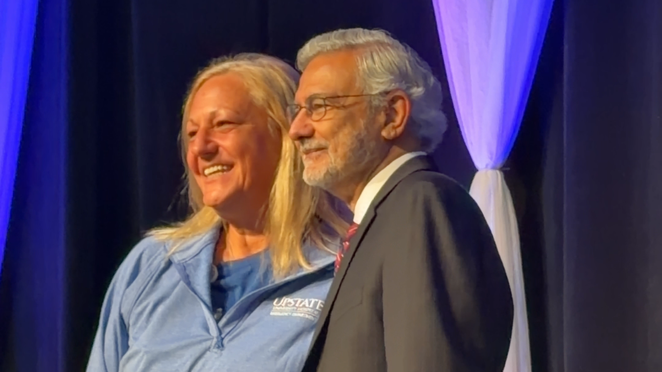 President Dr. Mantosh Dewan shaking hands and taking pictures with employees on the stage of Upstate's 42nd Annual Employee Appreciation Day at the Oncenter in downtown Syracuse.