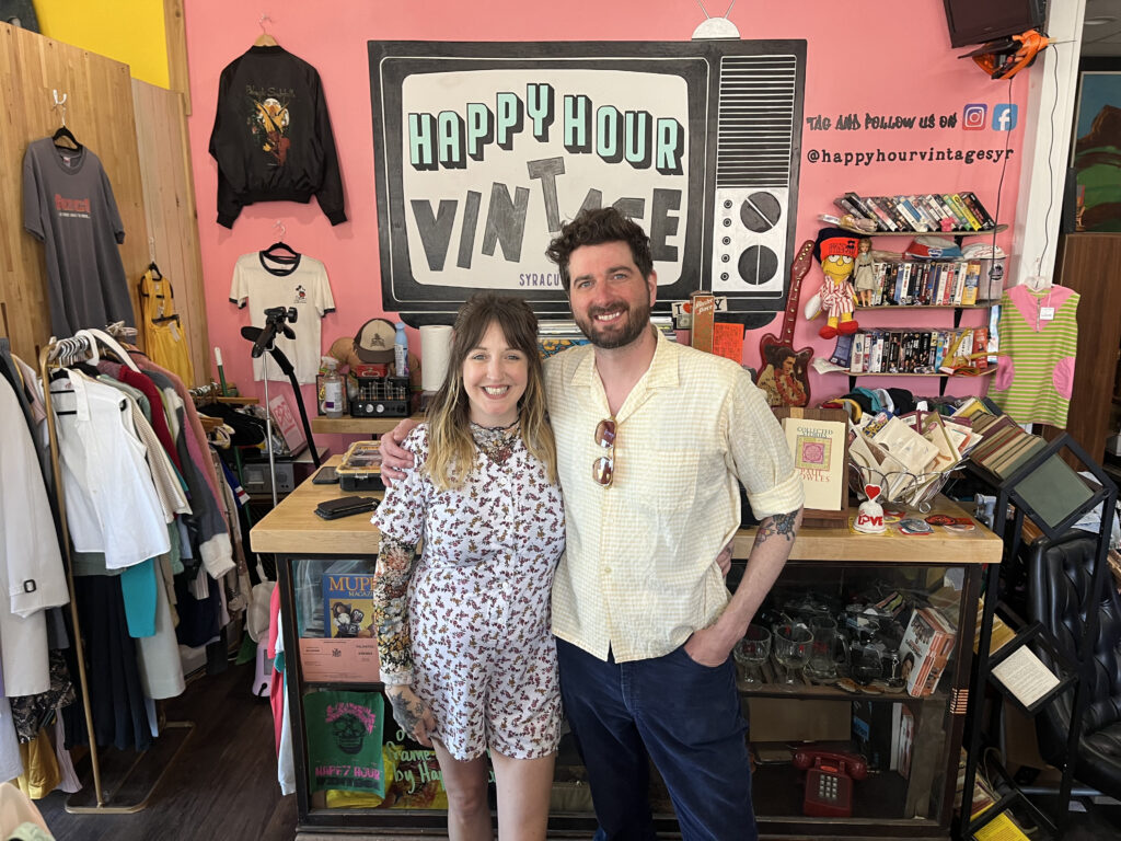 Co-owners Jake and Rebecca Patterson stand in front of cashier's desk at their Happy Hour Vintage store.