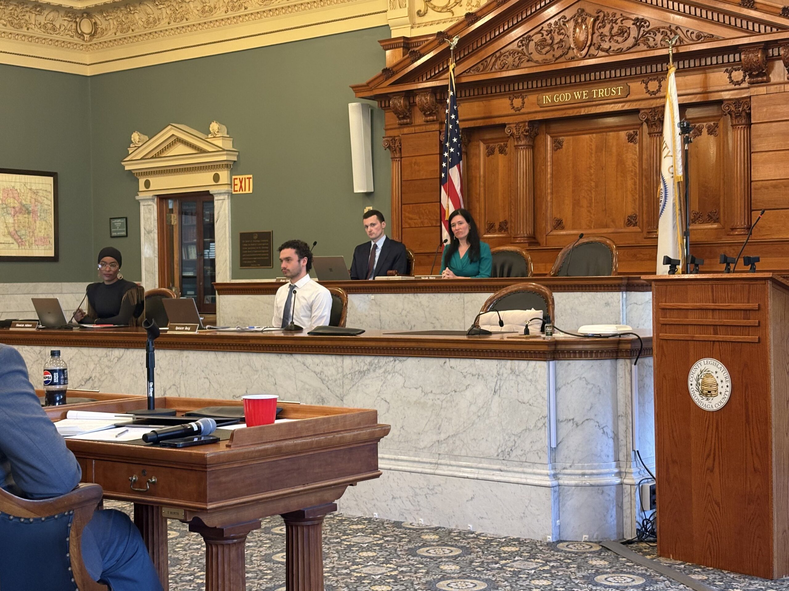 County legislative Chair Nicole Watts sits at an elevated marble desk overlooking the Onondaga County legislative session as they vote on term limits for the county executive.