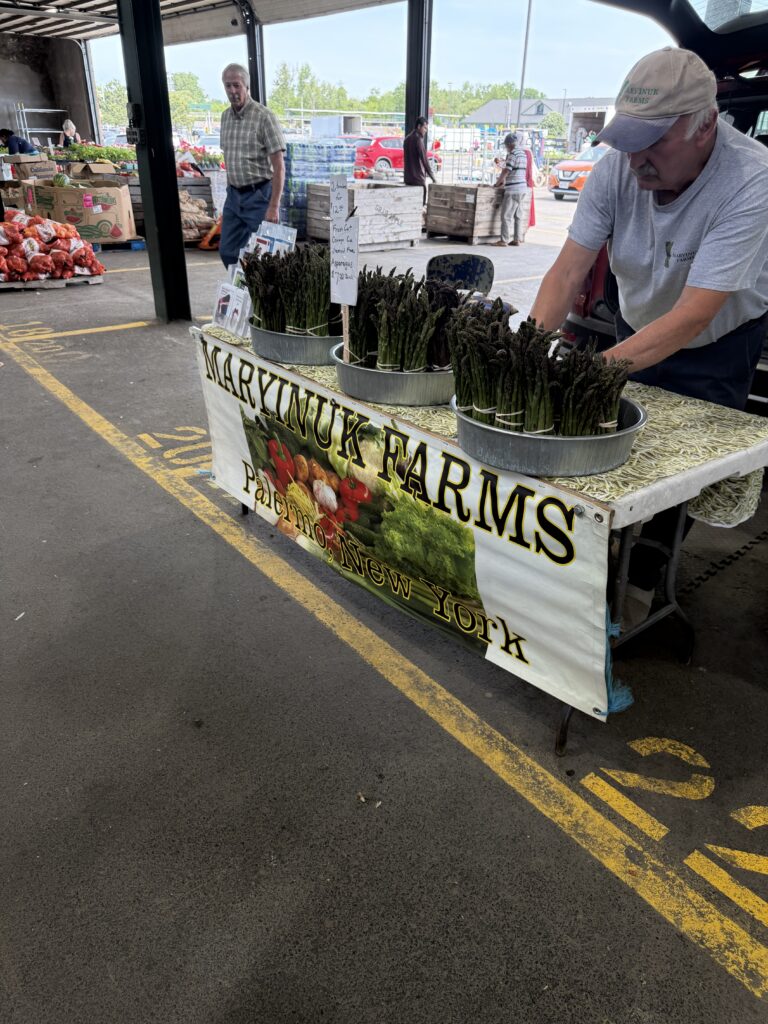 Jim Maryinuk of Maryinuk Farms arranging fresh-cut asparagus at his stand at the CNY Regional Market