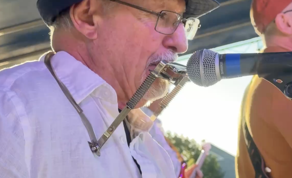 Man playing the harmonica in front of a microphone