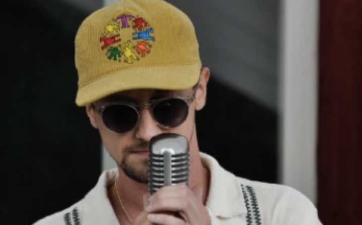 Man in yellow hat in front of microphone