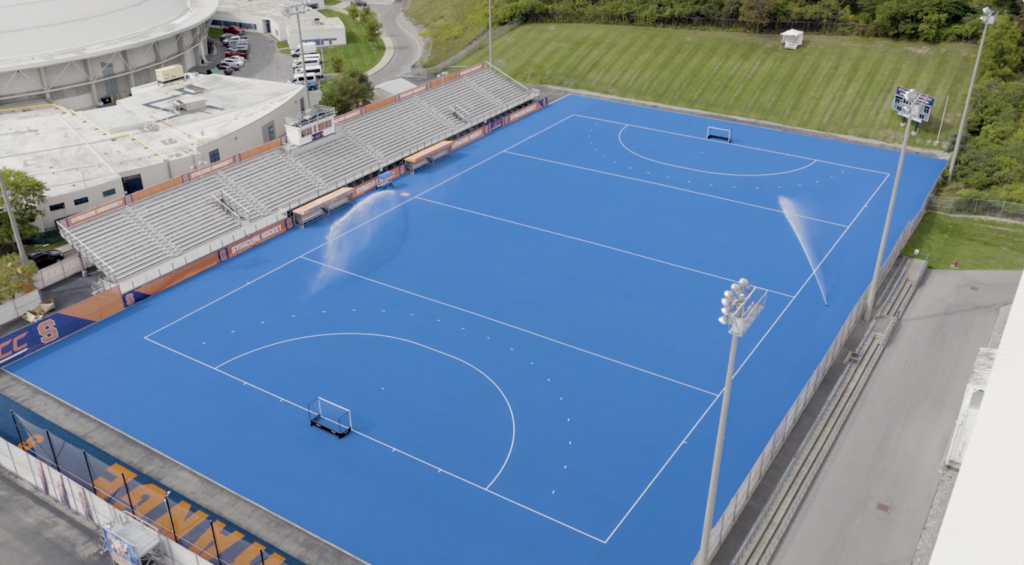 The AstroTurf at J.S. Coyne Stadium gets sprayed with water before practice.