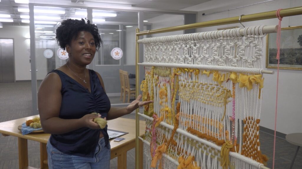 Tatianna Monet standing in front of her project, The Growing Hive
