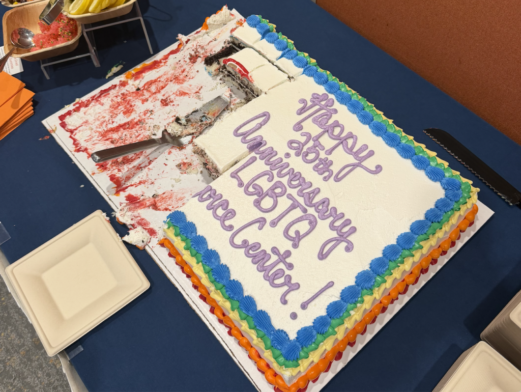 A white cake with rainbow borders that says, "Happy Anniversary LGBTQ Resource Center!"