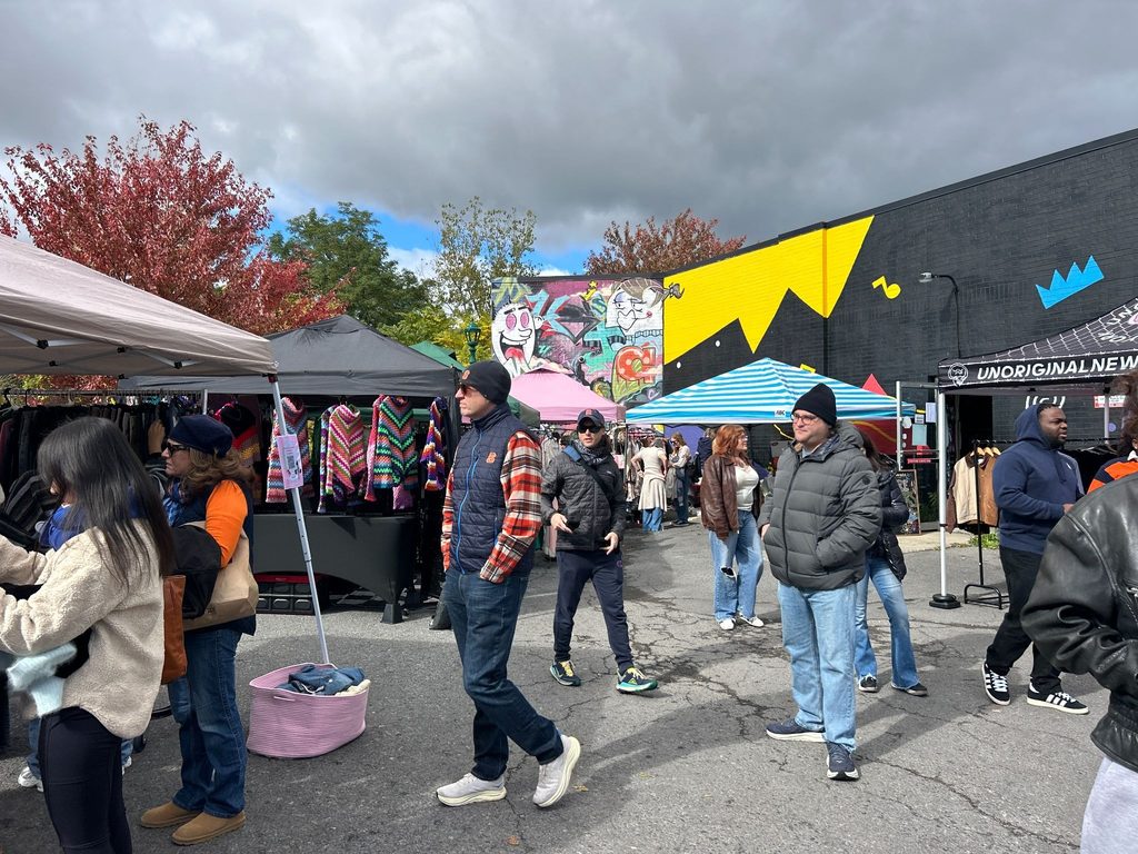Shoppers in jackets and beanies browse clothing racks at the Vintage in the Garden market at downtown Syracuses's Sound Garden.